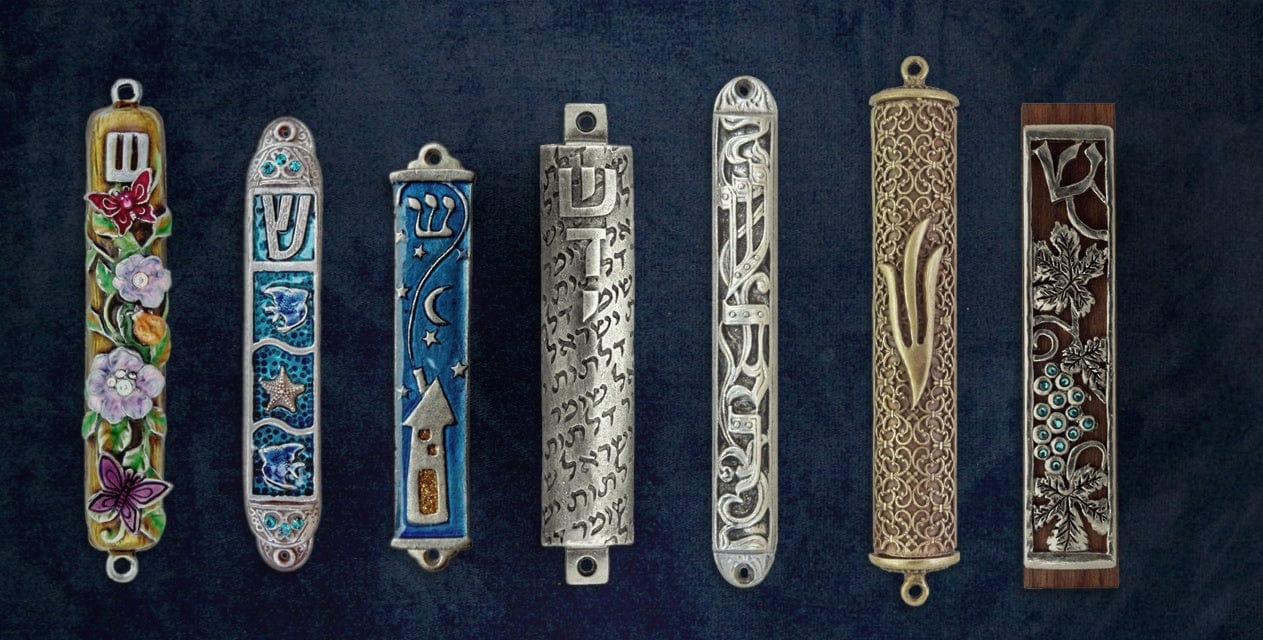Assorted decorative mezuzah cases with floral, Hebrew, and artistic designs on a blue background
