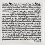 The 12 cm kosher mezuzah parchment laid flat, showing the complete handwritten Hebrew text in Sephardic Vellish script by a sofer stam in israel