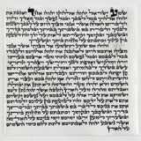 The 12 cm kosher mezuzah parchment laid flat, showing the complete handwritten Hebrew text in Sephardic Vellish script by a sofer stam in israel