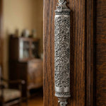 Traditional Mosaic Magen David Pewter Mezuzah mounted vertically on a richly textured wooden door