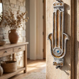 Hyper-realistic scene of a doorway with a protected inward-facing right-side mezuzah case, showcasing the amber and rust-toned Hamsa design.