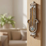 Amber Hamsa Guard Mezuzah on a sleek doorway with soft lighting, showcasing the hand painted enamel, amber tones, and Judaica design.