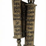 Crown-topped brass mezuzah case inspired by twin Torah scrolls, detailed Hebrew script, regal crown finials, on a white studio surface.