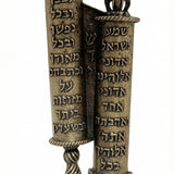 Crown-topped brass mezuzah case inspired by twin Torah scrolls, detailed Hebrew script, regal crown finials, on a white studio surface.