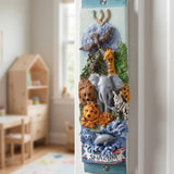 Lifelike lifestyle image of animal kingdom mezuzah on a doorway inside a child's room, showcasing colorful safari animals and a Shalom banner, crafted with detailed hand-painted design.