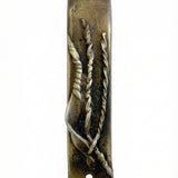 Antique brass Mezuzah measuring 4 inches in a bright, neutral white studio setting with soft reflection, showcasing fine details and craftsmanship.