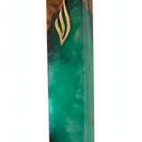 Angled studio view of the Artistic Olive Wood Emerald Green Resin Mezuzah, an olive wood mezuzah case from Israel with translucent emerald resin, rich brown wood grain and a gold Shin, holding a 6-inch kosher scroll
