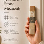 Close-up of a hand holding an authentic Jerusalem stone mezuzah case, showcasing its unique mineral tones and Hebrew design.