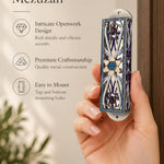 Handheld portrait of the Azure Radiance Star of David Mezuzah mezuzah cover, with silver-toned openwork, purple accents and a gold-colored Star of David with a sparkling blue center and blue border clearly visible beside the product name and illustrated features of this distinctive Jewish doorway design