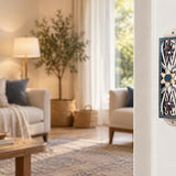 Azure Radiance Star of David Mezuzah mounted vertically on a pale home doorpost, with silver-toned openwork, purple accents and a gold-colored Magen David with a sparkling blue center and blue decorative border creating a distinctive mezuzah cover that brings its Jewish design and decorative detail into the doorway
