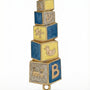 Hand painted blue and yellow baby mezuzah made of brass with enamel paint, 4 inches tall, displayed on a white background with soft reflection.