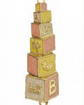 Hand-painted brass baby mezuzah in pink and yellow, 4 inches tall with Hebrew inscription, designed for nursery decor, with a bright white background.