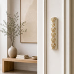 Baroque style gold and Jerusalem stone mezuzah case mounted vertically on a residential doorpost.