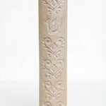 High-resolution image of a handcrafted Jerusalem stone Baroque style Mezuzah with detailed embellishments and natural stone variations, on a white background with soft reflection.