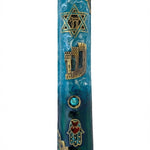 Elevated photo of a brass Beach Mezuzah with detailed Hebrew engravings, displayed on a clean white background with a subtle reflection.