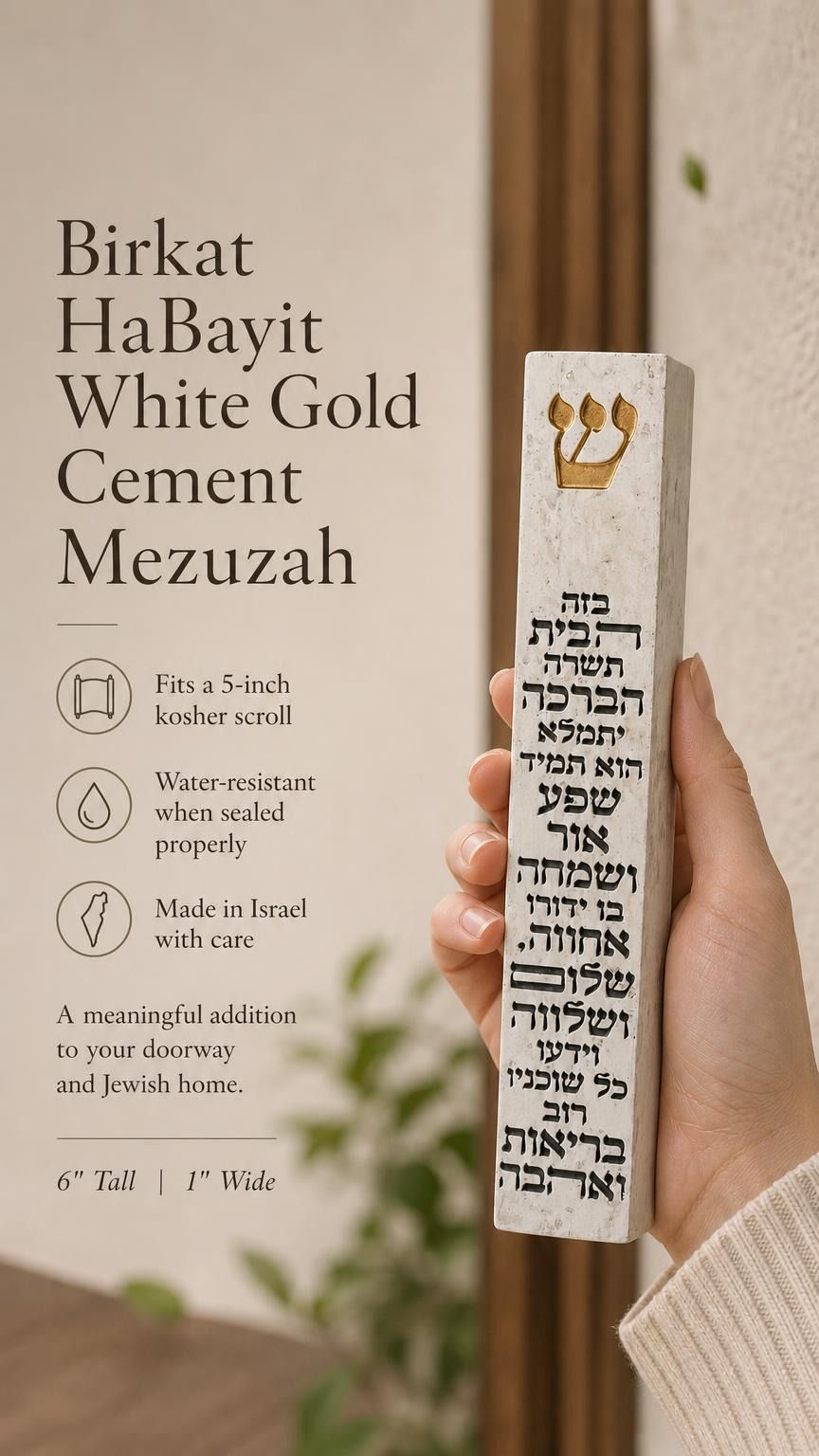 Hand holding a Birkat HaBayit White Gold Cement Mezuzah case with a raised gold Shin and full Hebrew home-blessing text printed vertically across the slim white cement body, shown in a warm neutral home setting