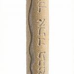 Handmade mezuzah from Jerusalem stone, engraved Hebrew blessing for home, with detailed relief and decorative motifs on a white background.