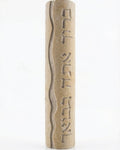 High-resolution image of handcrafted Mezuzah made of Jerusalem stone, engraved Hebrew blessing, on a white studio background with soft reflection.