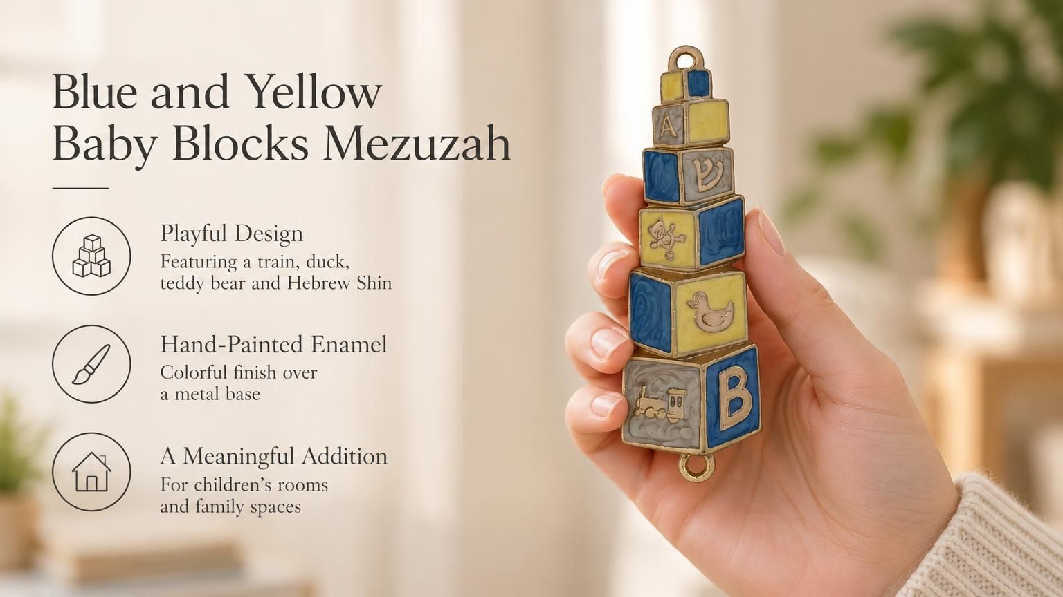 A hand holds a colorful, blue and yellow baby blocks mezuzah case featuring alphabet and toy decorations for a nursery