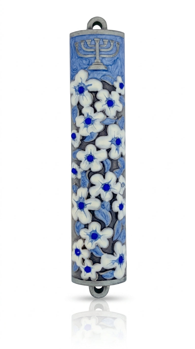 Elegant pewter mezuzah with blue enamel flowers, detailed Hebrew engravings, designed for home door blessing, with a white studio background and subtle reflection.
