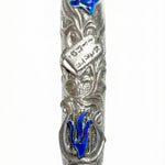 High-resolution image of a blue lily mezuzah made of pewter with enamel accents, featuring the Ten Commandments tablet among lily leaves, on a white studio background with soft reflection.