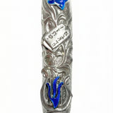 High-resolution image of a blue lily mezuzah made of pewter with enamel accents, featuring the Ten Commandments tablet among lily leaves, on a white studio background with soft reflection.