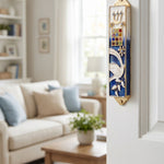 Twelve Jewels Dove Blue Mezuzah mounted on door frame with indoor room in background.