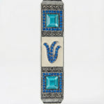 Petite blue stone mezuzah with Hebrew Shin letter and sparkling accents, made of pewter, designed for home doorposts with a polished white background.