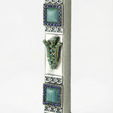 Petite blue stone mezuzah with Hebrew shin and sparkling accents showcasing detailed craftsmanship