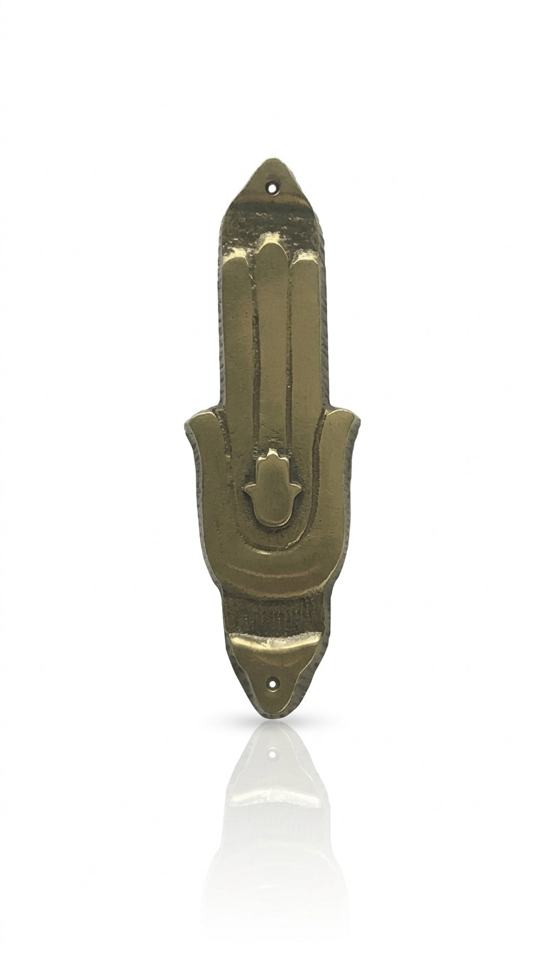 High-resolution image of a brass Hamsa Mezuzah with detailed engravings, resting on a polished white surface with a soft reflection for elegant display.