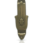 High-resolution image of a brass Hamsa Mezuzah with detailed engravings, resting on a polished white surface with a soft reflection for elegant display.
