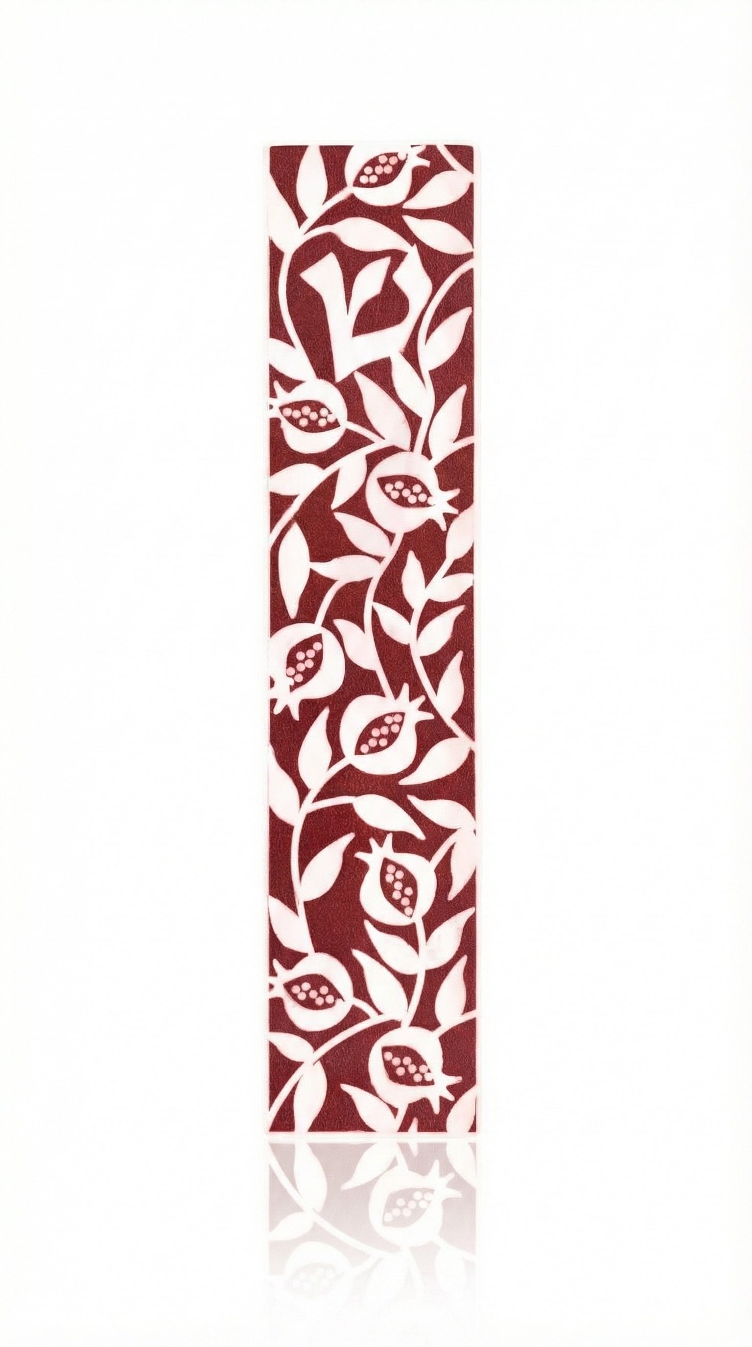 Elegant burgundy pomegranate mezuzah made of acrylic with detailed Hebrew engravings, set against a bright white background with a subtle reflection.