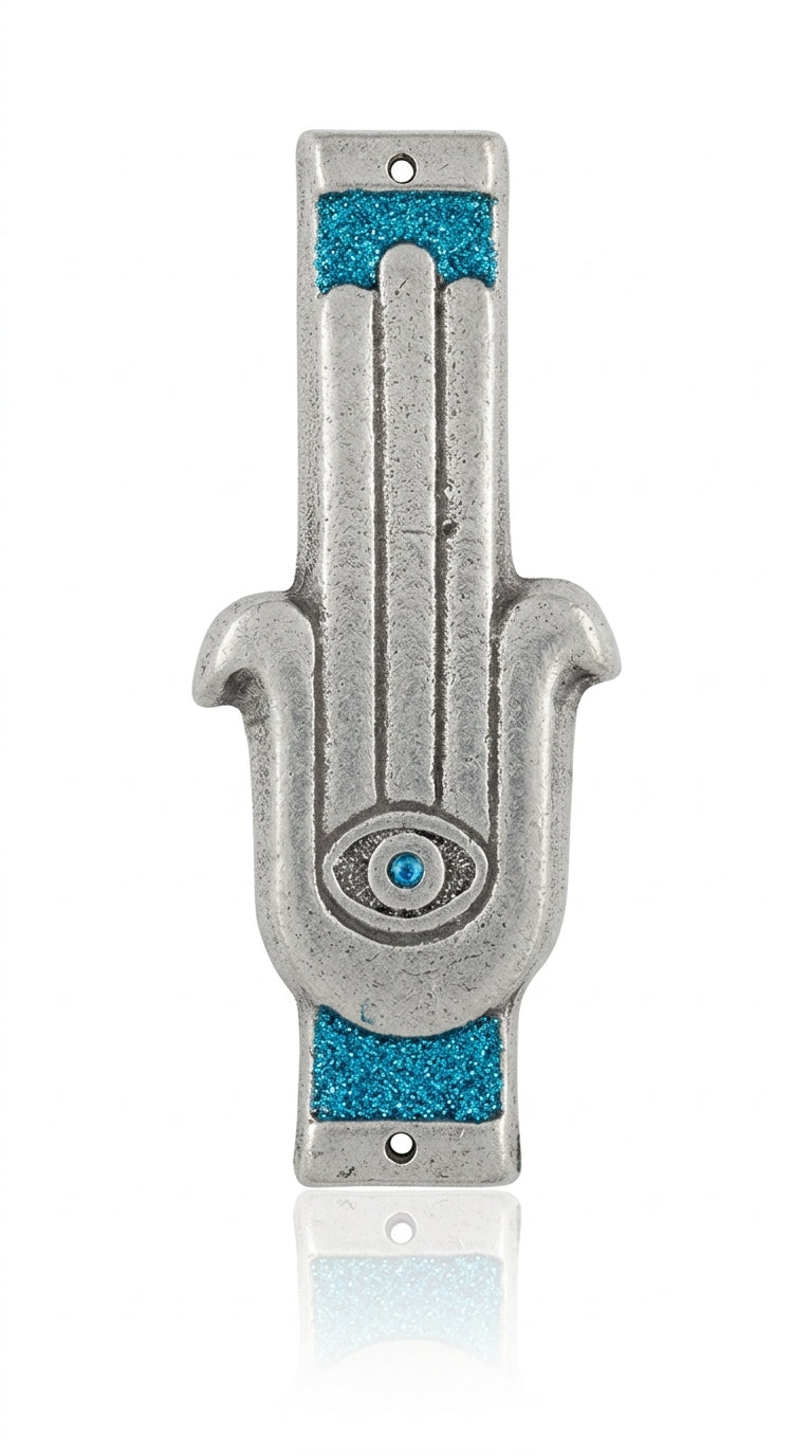 Blue Hamsa shaped Mezuzah with a central eye symbol, accented with silver and blue sparkling paint, placed on a white studio surface with soft reflection.