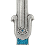 Blue Hamsa shaped Mezuzah with a central eye symbol, accented with silver and blue sparkling paint, placed on a white studio surface with soft reflection.
