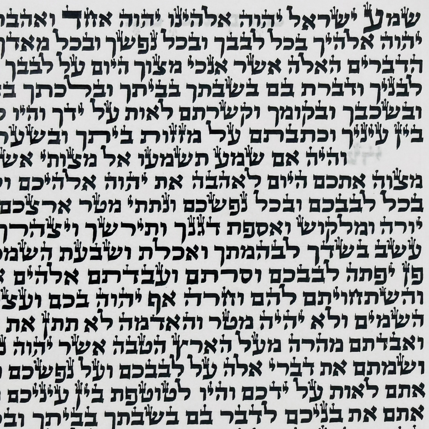 a certified kosher Sephardic mezuzah scroll handwritten on parchment in Sephardi Vellish-style ktav, with rounded Hebrew letter forms and traditional STaM crowns