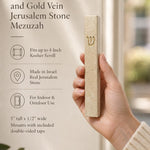 Hand holding the Classic Cream Gold Vein Jerusalem stone mezuzah case with raised gold Shin, shown beside product details for its 5-inch size, 4-inch kosher scroll fit, Israeli origin, and indoor or protected outdoor use