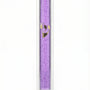 Transparent purple Lucite Mezuzah with Hebrew lettering, displayed upright against a white background with soft reflection.