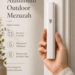 Close-up of a person holding the white aluminum outdoor mezuzah, emphasizing its profile and details.