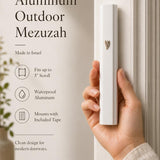 Close-up of a person holding the white aluminum outdoor mezuzah, emphasizing its profile and details.