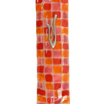 Vibrant fused-glass checkerboard Mezuzah with detailed Hebrew inscriptions, mounted on a white background with a soft reflection.