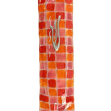 Vibrant fused-glass checkerboard Mezuzah with detailed Hebrew inscriptions, mounted on a white background with a soft reflection.