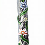 Vibrant hand-painted floral enamel mezuzah with crystal accents on pewter, displayed vertically against a clean white studio background with a subtle reflection.