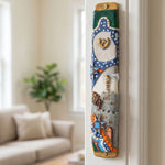 Vivid colorful Kotel Gate mezuzah with Jewish symbols, mounted inside a doorway on a true jamb, displayed in a lifestyle scene.
