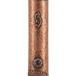 Copper and blue stone mezuzah mounted on a white studio background with a soft reflection, showcasing detailed engravings and textured surface.