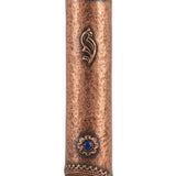 Copper and blue stone mezuzah mounted on a white studio background with a soft reflection, showcasing detailed engravings and textured surface.