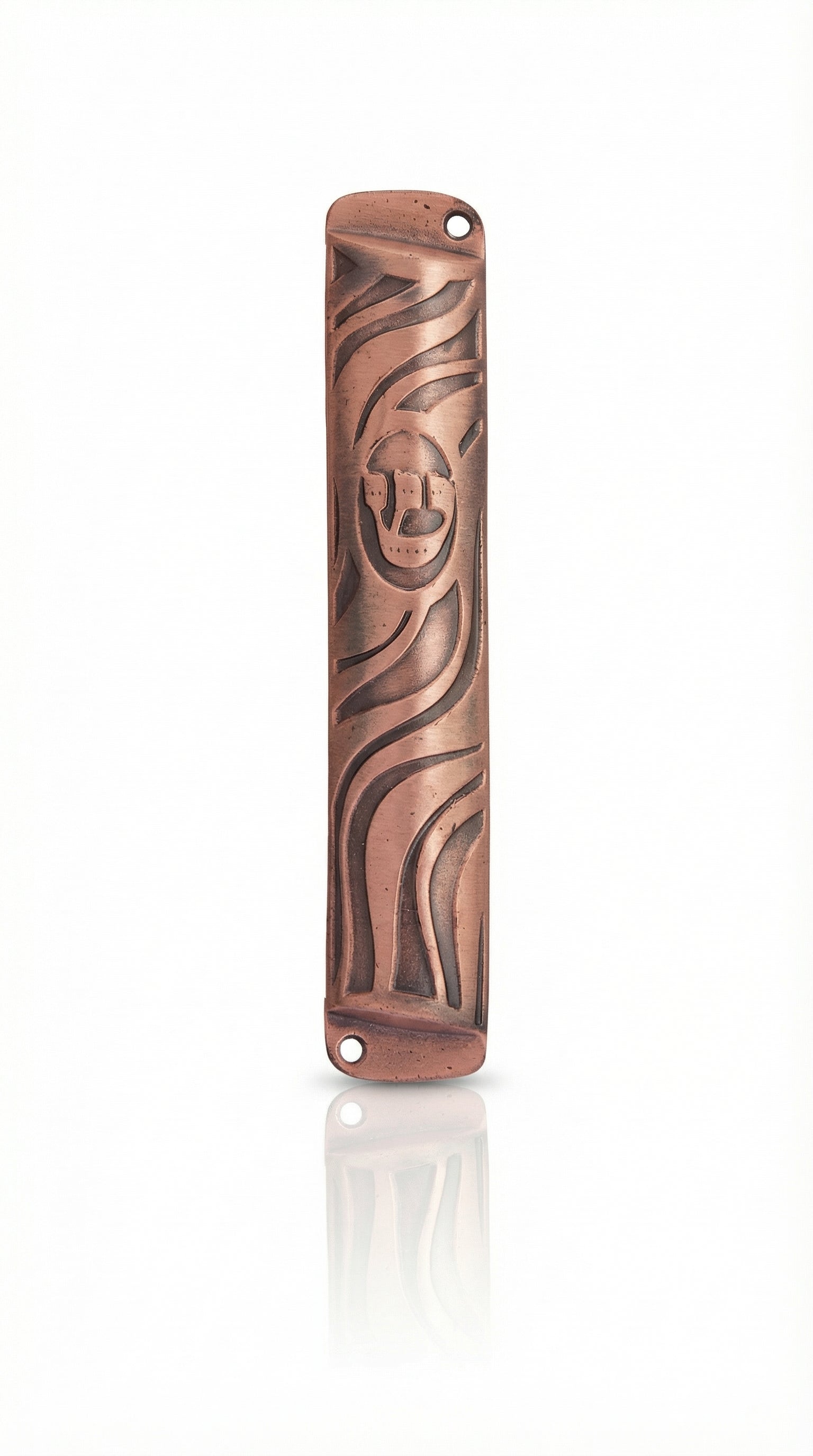 High-resolution image of a petite copper mezuzah with intricate design, Hebrew engravings, and a bright copper finish, on a white studio surface.