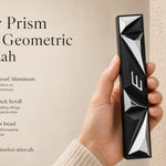 Black and silver geometric mezuzah attached to a doorpost, showcasing angular prism panels and Hebrew shin.