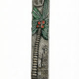 Detailed view of a handcrafted pewter mezuzah with colorful enamel accents, mounted on a white background with soft studio reflection.