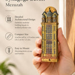 Handheld portrait of the Die Neue Synagoge Berlin Mezuzah mezuzah cover, with golden ochre Fimo polymer clay shaped as the Berlin synagogue facade, with gray domes, tall windows and architectural relief clearly visible beside the product name and illustrated features of this distinctive Jewish doorway design