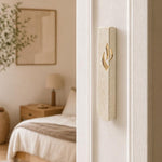 Close-up of Jerusalem stone mezuzah mounted on a residential doorpost in a natural entryway scene.